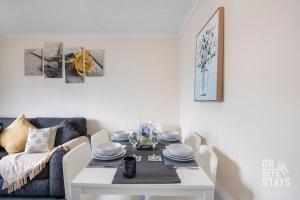 a dining room with a white table and a couch at Contractors 4 Bed with Parking in Hatfield +13 photos