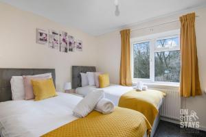 two beds in a room with yellow and white at Contractors 4 Bed with Parking in Hatfield