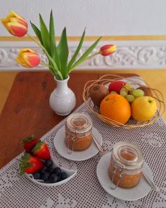 a table with two baskets of fruit and jars of honey at Dolceresio Lugano Lake B&B in Brusino Arsizio