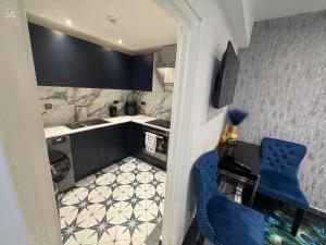 a small kitchen with black cabinets and a blue chair at Gloucester - Apartment - Sleeps 2 - Parking - 97WS in Gloucester