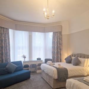 a bedroom with two beds and a couch and a window at St Margaret's Hotel in Oxford