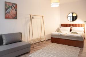 ローバウにあるExklusives City-Apartment am Altmarktのベッドルーム(ベッド1台、ソファ、鏡付)