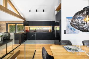 una cucina e una sala da pranzo con tavolo e sedie in vetro di Chalet Le Reve Cinema room Jacuzzi a Riddes Altre 13 foto