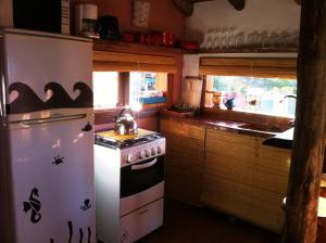 a kitchen with a stove and a refrigerator at Arándanos in Punta Del Diablo