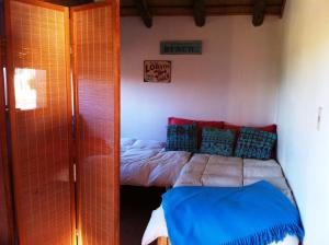 1 dormitorio con 1 cama con almohadas azules y rojas en Arándanos, en Punta del Diablo