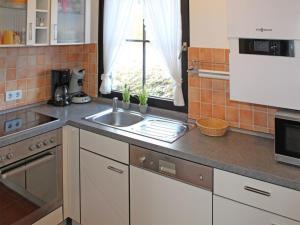 une cuisine avec un évier et une fenêtre dans l'établissement Ferienhaus Nr 30, Kategorie Komfort Plus, Feriendorf Hochbergle, Allgäu, à Lechbruck am See