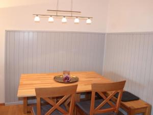 une table en bois avec deux chaises et une assiette dessus dans l'établissement Ferienhaus Nr 30, Kategorie Komfort Plus, Feriendorf Hochbergle, Allgäu, à Lechbruck am See