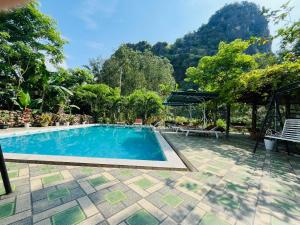 a swimming pool with a mountain in the background at Phong Nha Moonlight Villas in Phong Nha