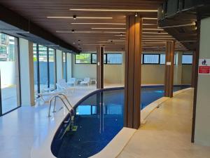 a swimming pool in a large room with windows at Bi Residence Sea View luxury Batumi in Batumi