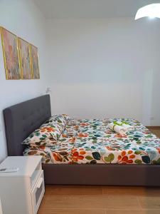 a bedroom with a bed with a floral comforter at Studio 49 - da Frank in Giardini Naxos
