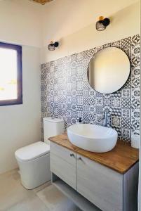 a bathroom with a sink and a toilet and a mirror at Ca Turón casa de pueblo in Planes