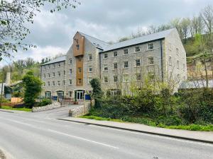 ein großes Gebäude am Straßenrand in der Unterkunft Rock Mill - Luxury 1 Bedroom Apartment 20 in Stony Middleton
