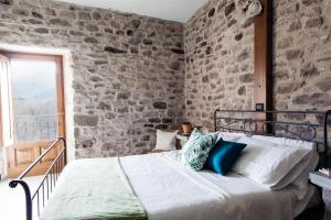 a bed in a room with a stone wall at Ca'Luni in Casola in Lunigiana