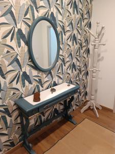 a mirror on a wall with a bench and a tripod at Palacongressi city center in Rimini