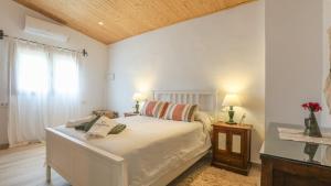 ein Schlafzimmer mit einem Bett mit zwei Lampen und einem Fenster in der Unterkunft Huerta Valleciruelo Sanlúcar La Mayor by Ruralidays in Sanlúcar la Mayor