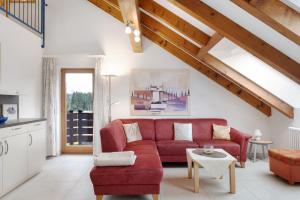 un soggiorno con un divano rosso e un tavolo di Haus Titisee a Titisee-Neustadt