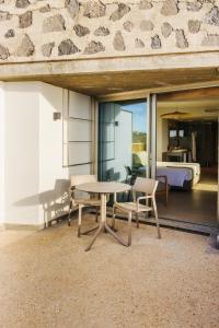 a table and chairs in a room with a bedroom at BANCAL HOTEL and SPA in San Sebastián de la Gomera
