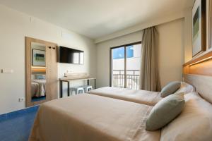 a hotel room with two beds and a window at The Blue Apartments - Adults Only in San Antonio