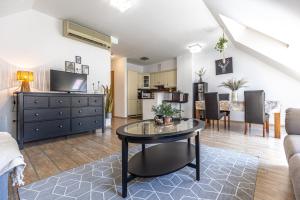 a living room with a table and a dining room at Gozsdu White Raven Residence 504 with free underground parking in Budapest