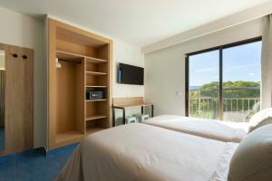 a bedroom with two beds and a window at The Blue Apartments - Adults Only in San Antonio