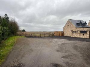 an empty parking lot in front of a stone building at Mill House The Lodge in Upwell