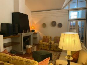 a living room with a couch and a television at Casa de Santiago in São Tiago de Besteiros