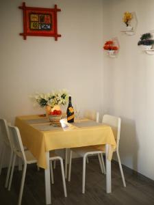 a dining room table with a bottle of wine and flowers at Casina Viareggina 2 camere in Viareggio