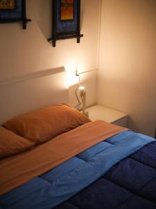 a bedroom with a bed and a lamp on a table at Casina Viareggina 2 camere in Viareggio