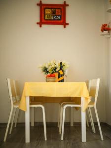 a dining room table with two chairs and a yellow table cloth at Casina Viareggina 2 camere in Viareggio