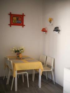 a dining room table with a yellow table cloth and chairs at Casina Viareggina 2 camere in Viareggio +29 photos
