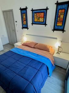a bedroom with a blue bed with stained glass windows at Casina Viareggina 2 camere in Viareggio