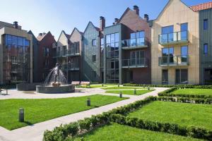 a courtyard with a fountain in front of a building at Dom & House - Old Town Tandeta in Gdańsk