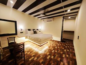 曼德姆Kiom cottages and homestay的一间卧室,里面有一张床、一张桌子和几把椅子。
