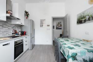 cocina y comedor con mesa y nevera en Georgehouse Golfo dei Poeti 5 Terre, en La Spezia