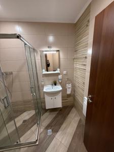 a bathroom with a sink and a shower at From Sunrise to Sunset at Oak Residence Smolyan in Smolyan
