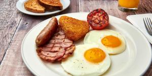 a plate of breakfast food with eggs sausage and toast at Delta Hotels by Marriott Birmingham in Birmingham
