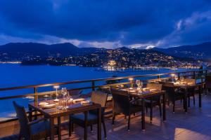 a restaurant with tables and chairs on a balcony at night at Grand Hotel Bristol Spa Resort, by R Collection Hotels in Rapallo