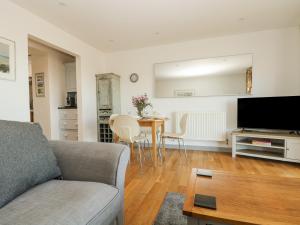 ein Wohnzimmer mit Sofa und Tisch in der Unterkunft Catch the Wave in Newquay