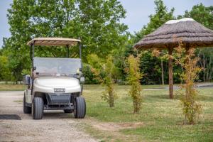 a golf cart parked next to a hut at Camping Seasonova Le Plan d'Eau in Saint-Yrieix-sur-Charente