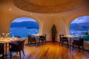 a restaurant with tables and chairs and large windows at Grand Hotel Bristol Spa Resort, by R Collection Hotels in Rapallo