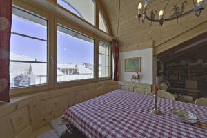 a dining room with a table and two windows at Chesa Mastrel - Silvaplana in Silvaplana +24 photos
