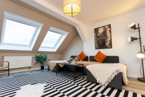 a living room with two beds and a desk at Macabu Apartment Linda in Chemnitz