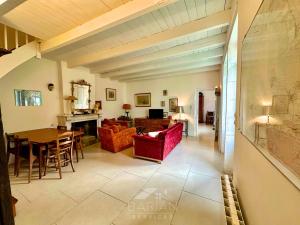 - un salon doté d'un mobilier rouge et d'une table dans l'établissement Charmante Maison Familiale - Grande Capacité, à Saint-Laurent-de-la-Prée