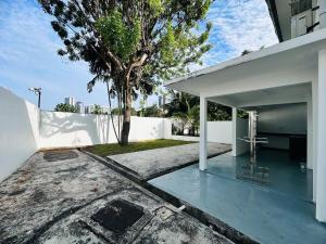 ein weißes Haus mit einem Kreuz auf dem Boden in der Unterkunft New Island Luxe Retreat Vacation Home 14pax Nearby Gurney in Tanjung Bungah