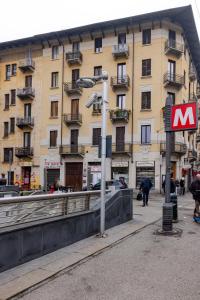 un panneau sur un poteau devant d'un bâtiment dans l'établissement Completa di tutto, Metro Fiere Università Ospedali, à Turin