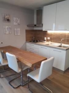 eine Küche mit einem Holztisch, Stühlen und einem Waschbecken in der Unterkunft Venice b&b la Pergola 2 in Spinea