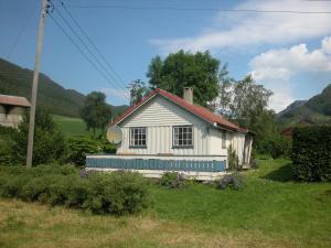 a small white house with a red roof at Haugland Gard in Haugaland