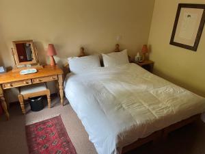 a bedroom with a bed and a desk with a mirror at High Trenhouse in Settle