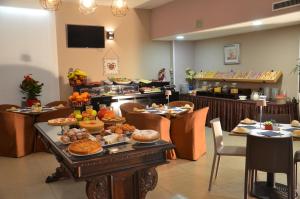 a buffet line with a table full of food at Green Hotel in Vergiate