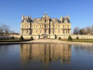 a large castle with a lake in front of it at Maison 3 chambres 6 pers RER A, L Paris direct in Maisons-Laffitte